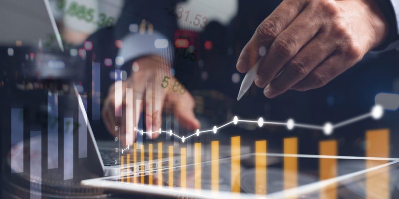 Business analysis, financial investment concept. Businessman, analyzing stock market report on digital tablet and laptop computer with market summary and financial graph